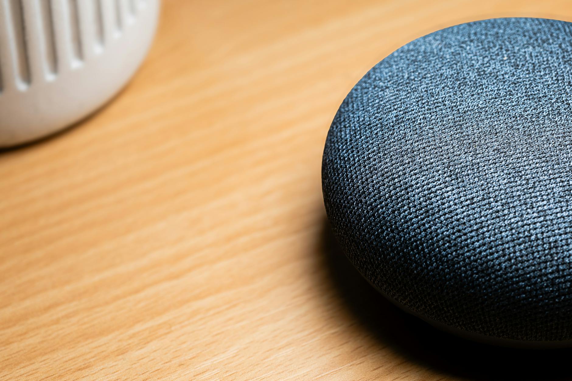 Smart speaker on wooden table demonstrating voice-activated Google Business Profile review automation capabilities