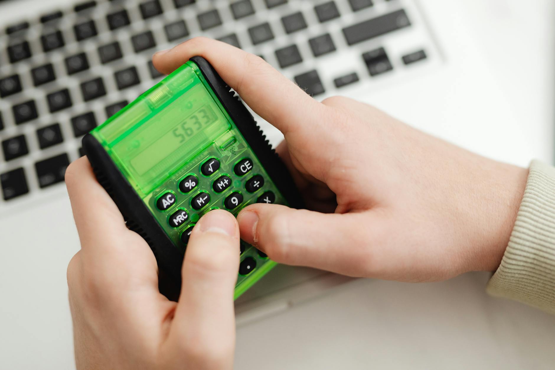 Small business owner calculating Google Ads monthly budget on calculator and laptop in Australia